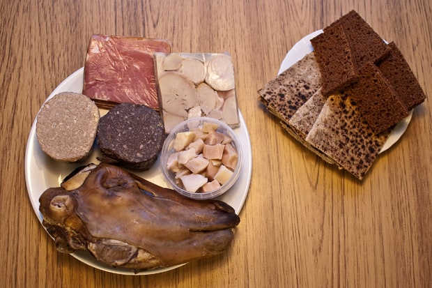 Vlevo: uzené jehněčí maso, tlačenka z beraních varlat, klobása z ovčích jater, krvavý puding (jelito), kostky žraločího masa, ovčí hlava. Vpravo: žitný chléb a chlebové placky. 