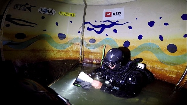 Jistící potápěč Michal Guba v dekompresním stanu v hloubce 9 metrů.